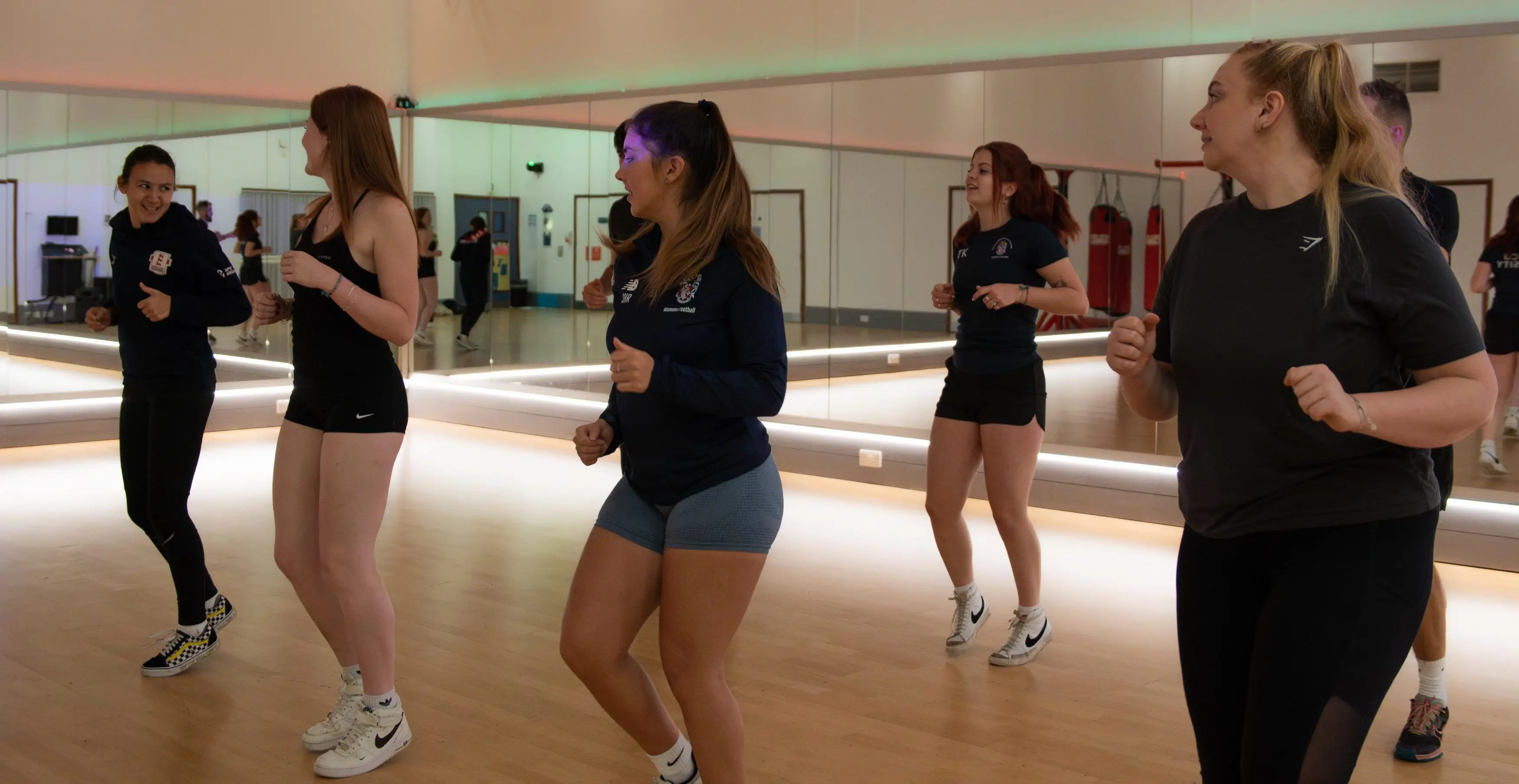 A group of females doing a dance class