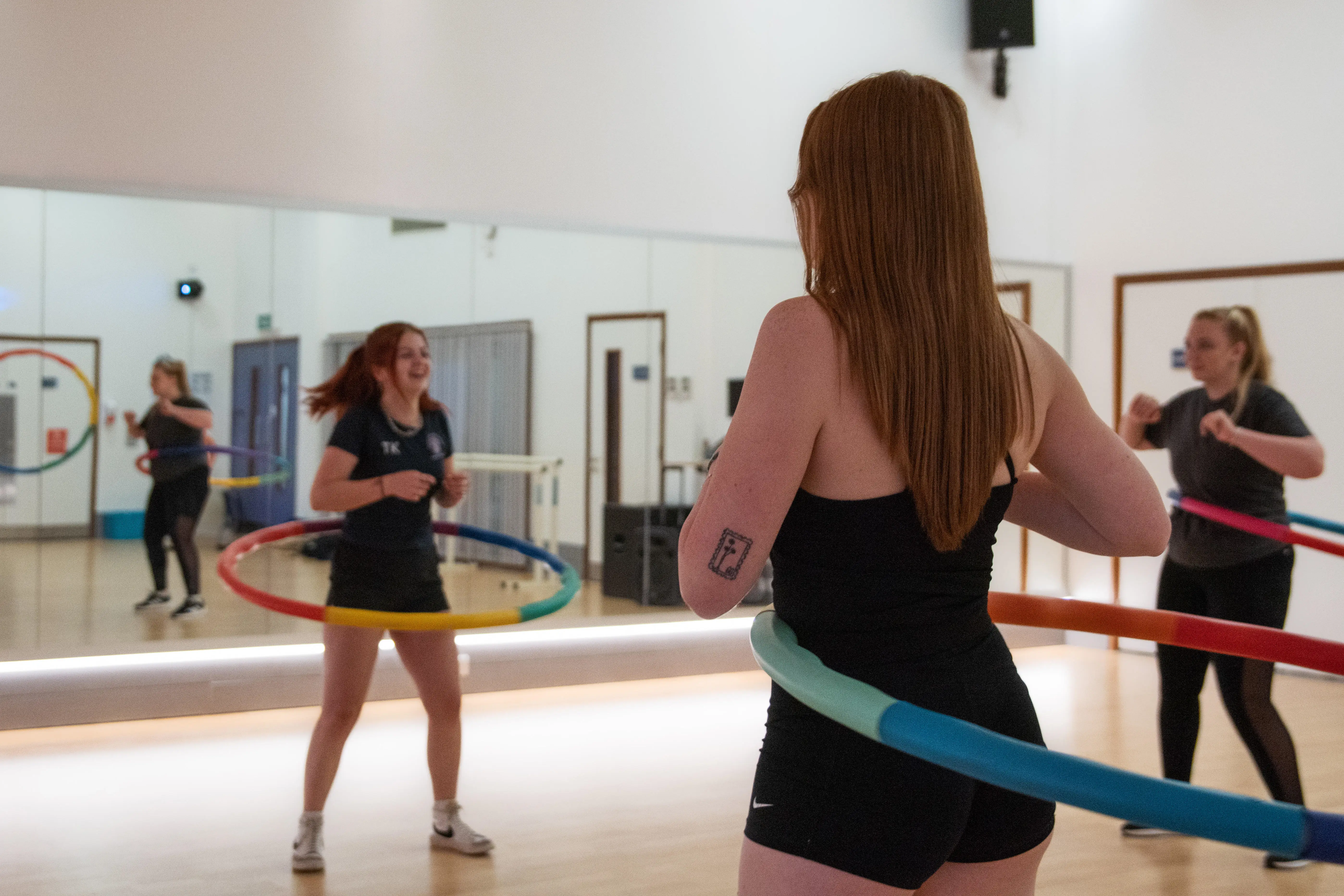 Participants using hula hoops in the fitness studio