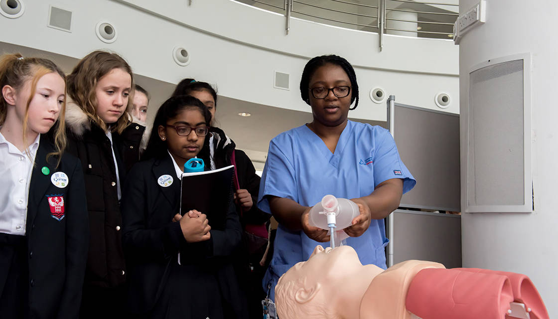 A group of school girls watching a resuscitation demo led by a STEM Ambassador at a STEM Hub event