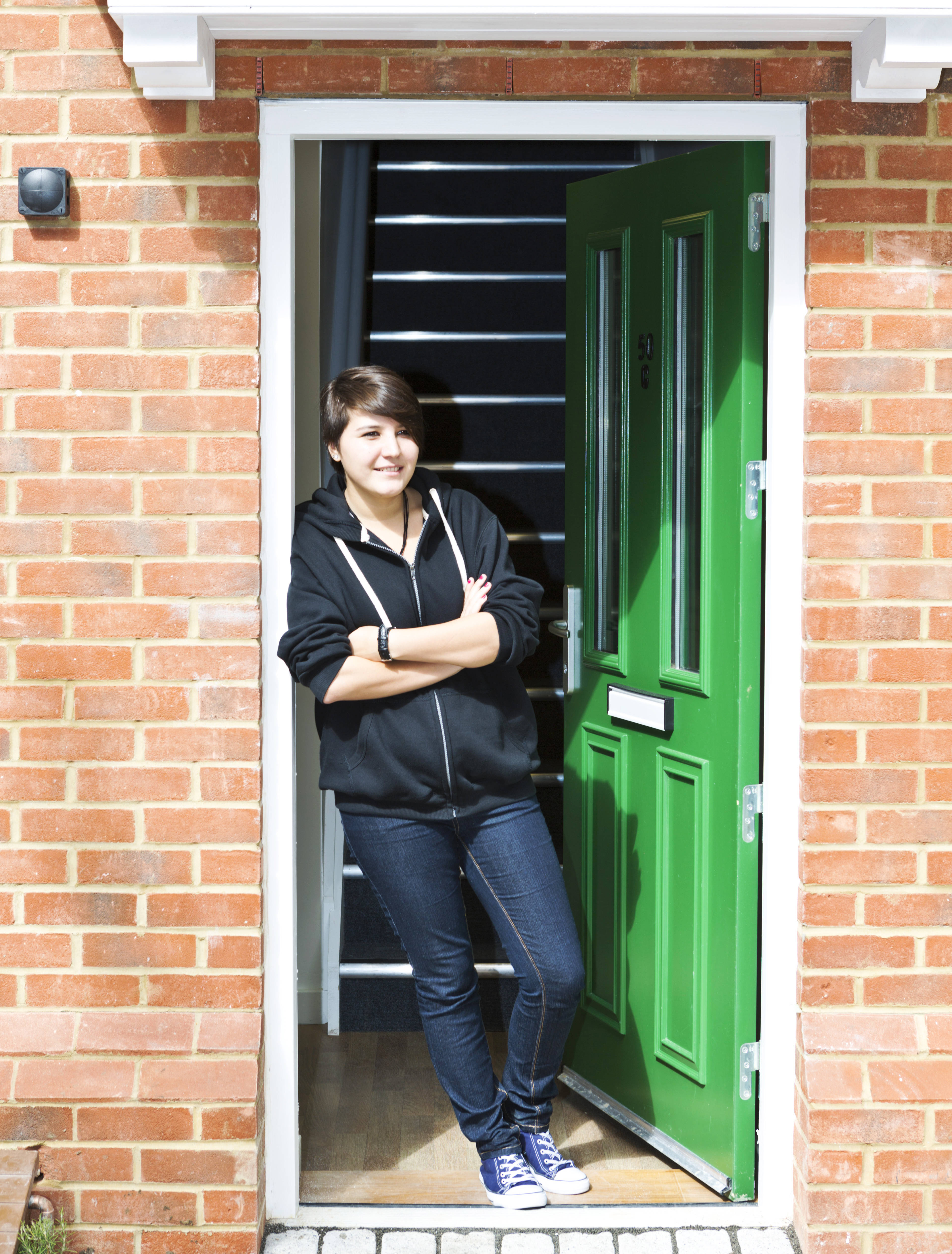 Student standing in the doorway to an accommodation.