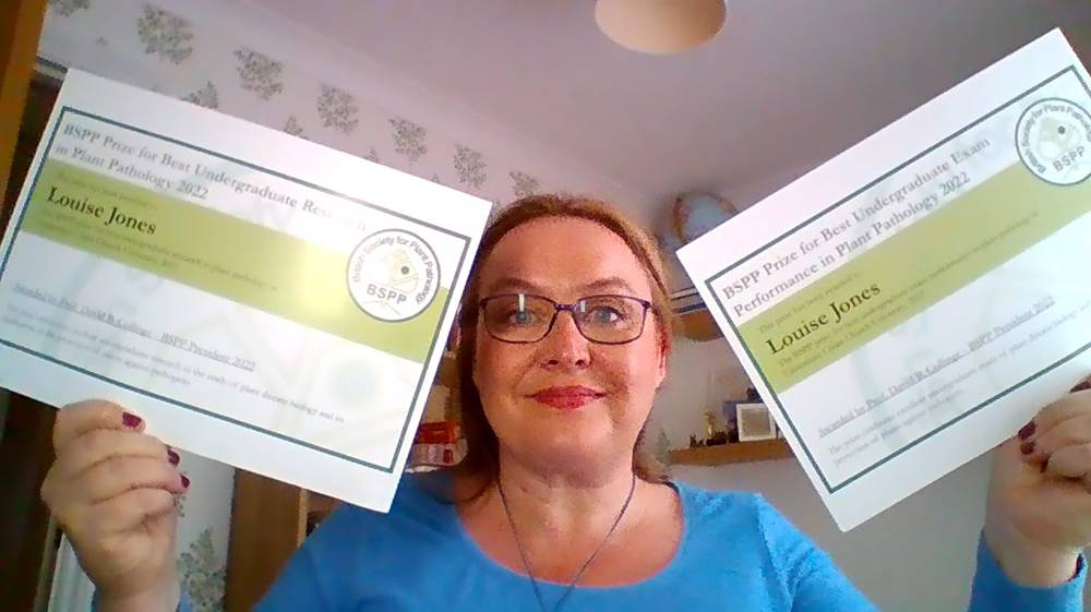 Louise holding her certificates 